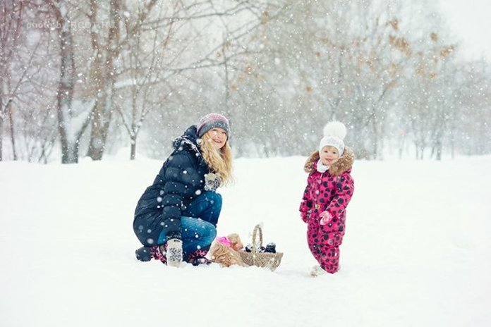 Мама и ребенок гуляют в снежную погоду